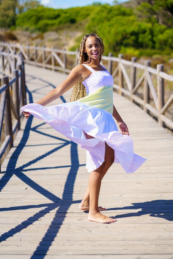 Happy female dancing in colorful dress on a pedestrian walkway