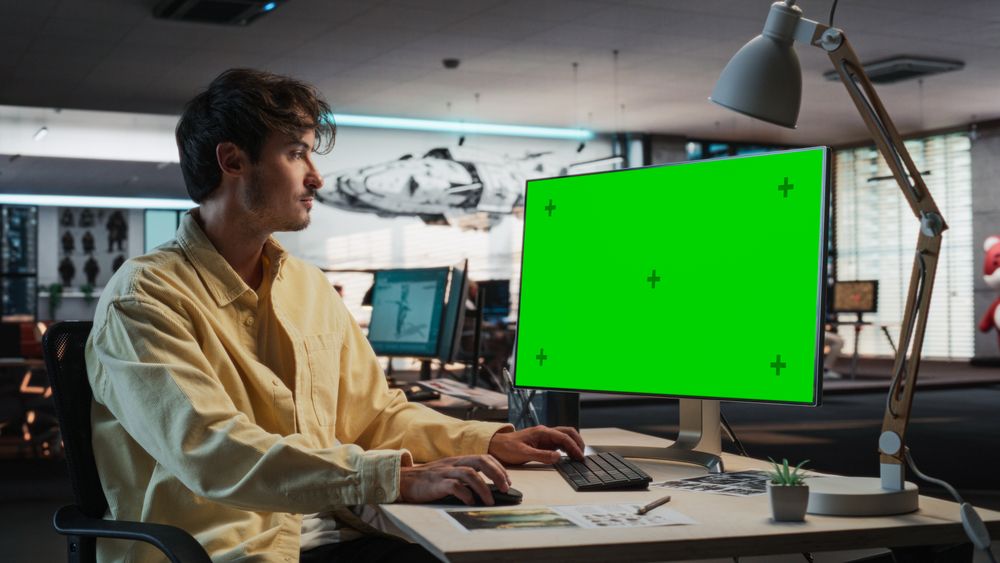 Man Using Desktop Computer with Mock-up Green Screen Chromakey.