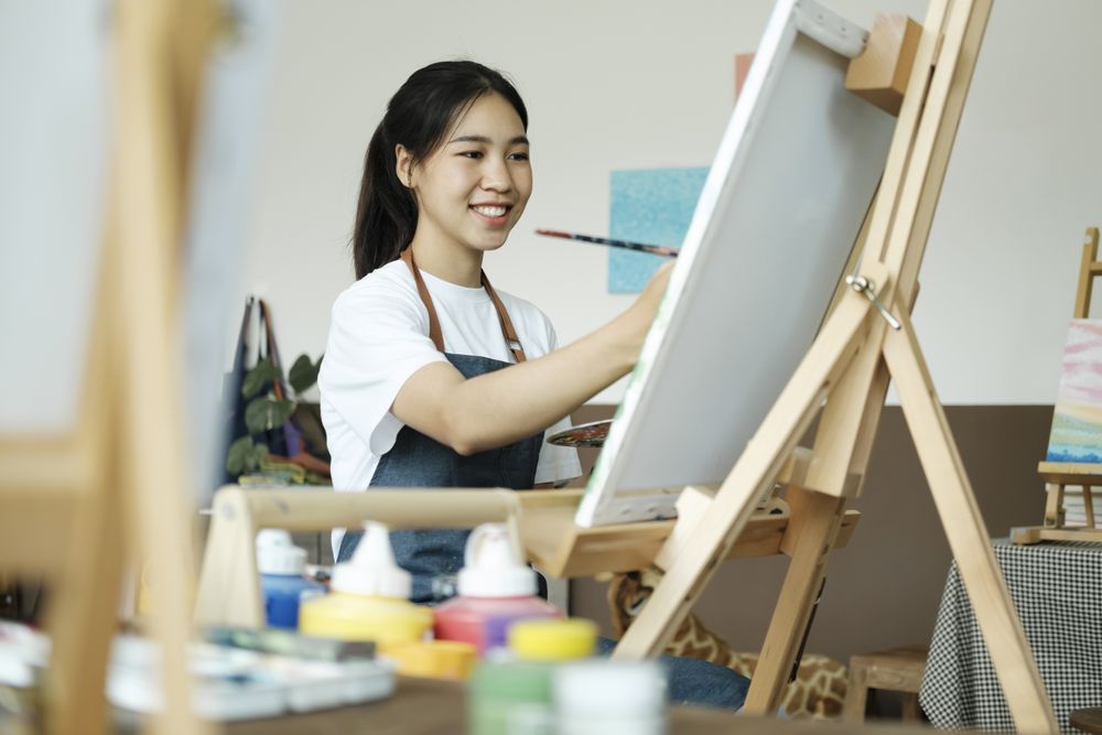 Crafting Inspiration. Female Artist Sketching and Painting in Workshop