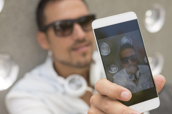 Picture of man in sunglasses taking picture of himself