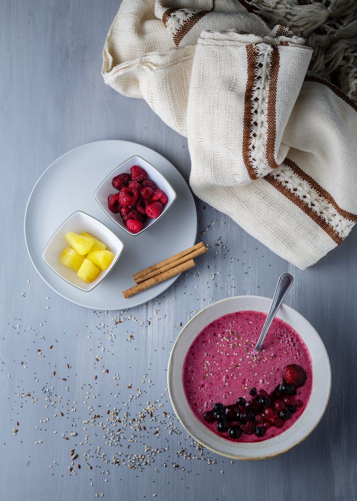 Smoothie bowl with fresh berries and sesame served on table