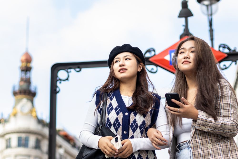 Asian young female friends walking on the street in the city