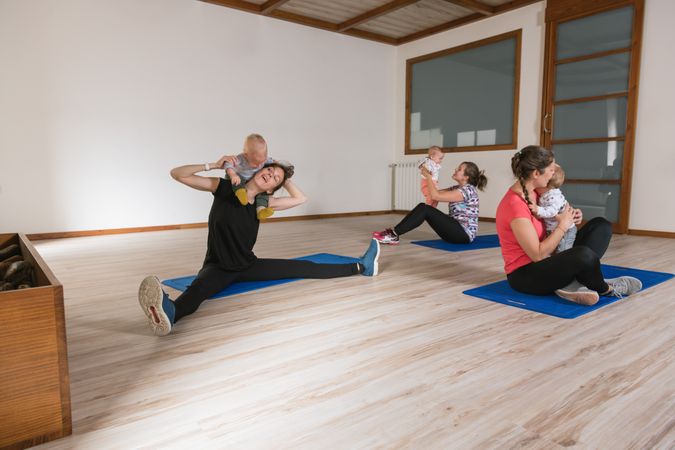 Mothers exercising with babies in gym