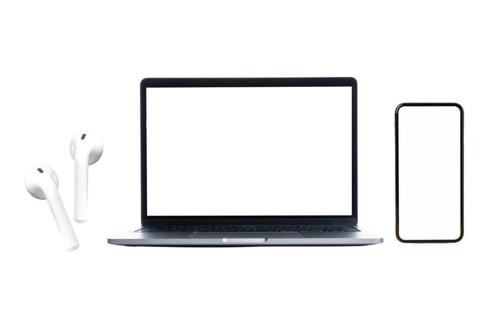 Laptop, smartphone, and earbuds on a white background