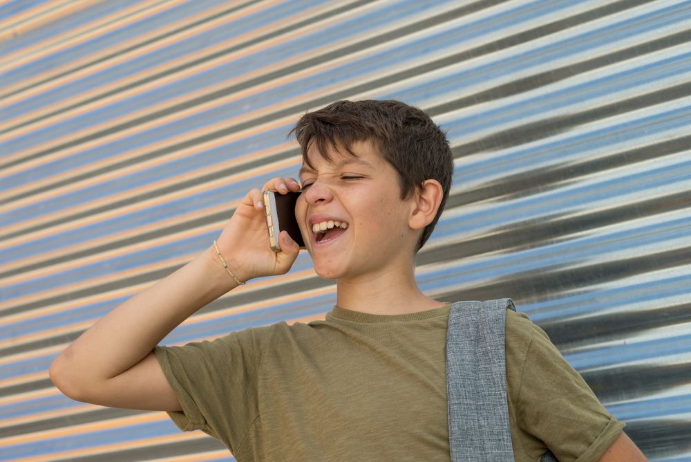 Teenager having funny conversation in front of metal shutter