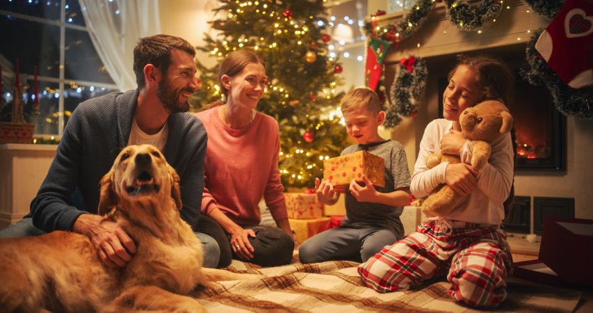 Happy Family on Christmas Eve: Caring and Thoughtful Husband Giving a Gift to His Wife While Celebrating the Holiday.