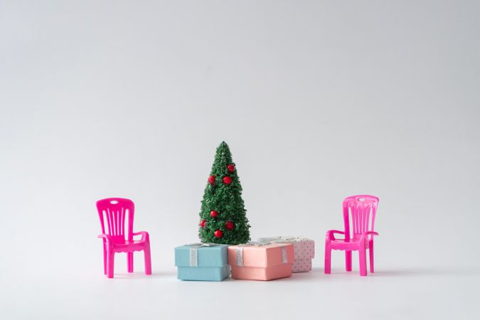 Christmas tree with presents underneath and pink chair