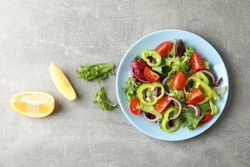 Salad of fresh vegetables on grey background, top view