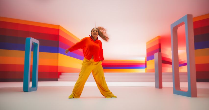 Colorful Geometric Abstract Aesthetic: Portrait of Black Woman Happily Dancing to Energetic Music in a Studio. Lively Female Dancer Celebrating Life and Youth, Expressing Herself Through Movement