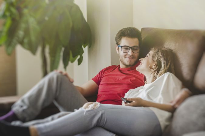 Happy couple watching TV on sofa