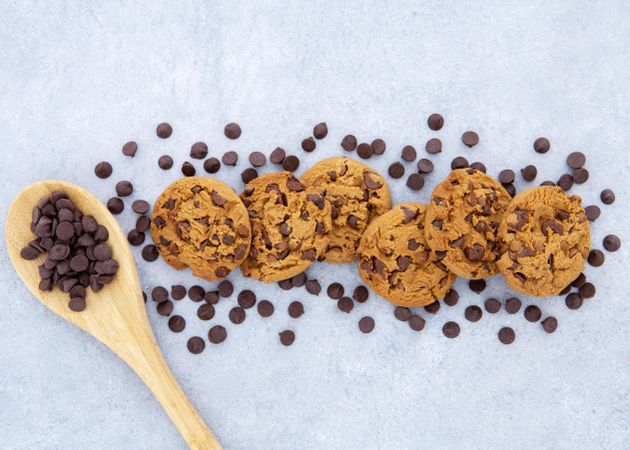 Arrangement of cookies surrounded by chocolate chips and spoon