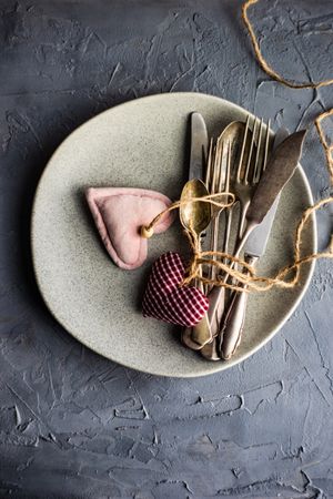 St. Valentine day table setting with felt hearts and cutlery with copy space