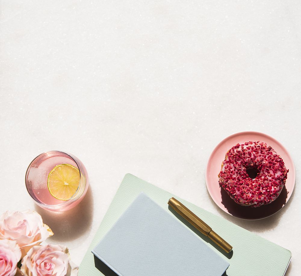 Sunny office desk flat lay on light marble with roses