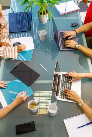 Faceless colleagues working at laptops in office