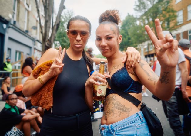 London, England, United Kingdom - August 28, 2022: Two female friends with liquor bottle outside