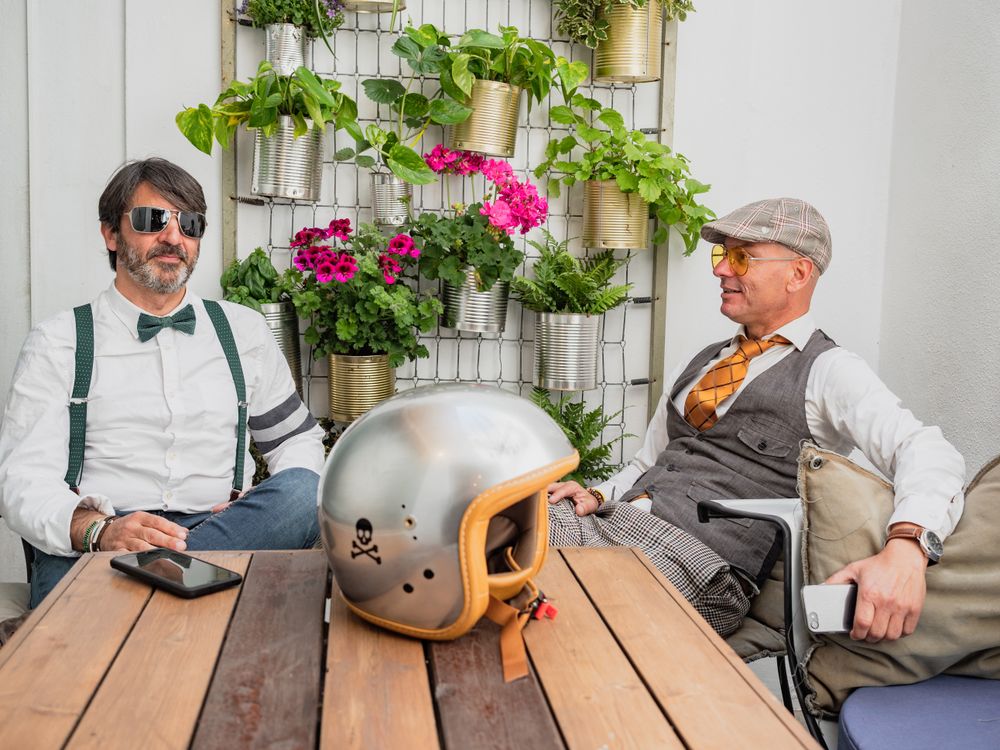 Trendy friends resting at table outdoors