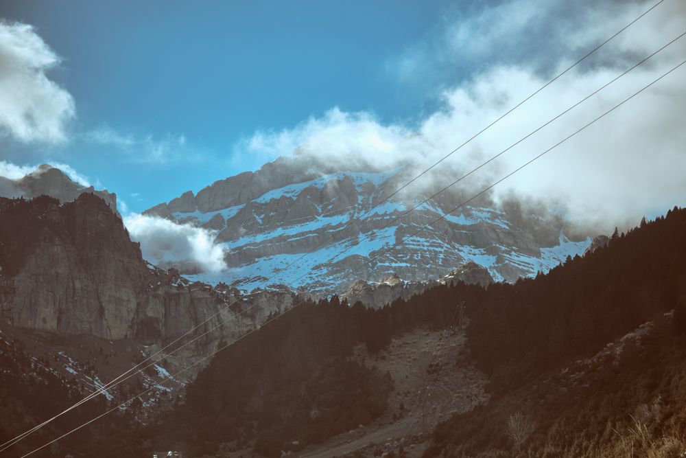 Snowy mountains with power lines in nature