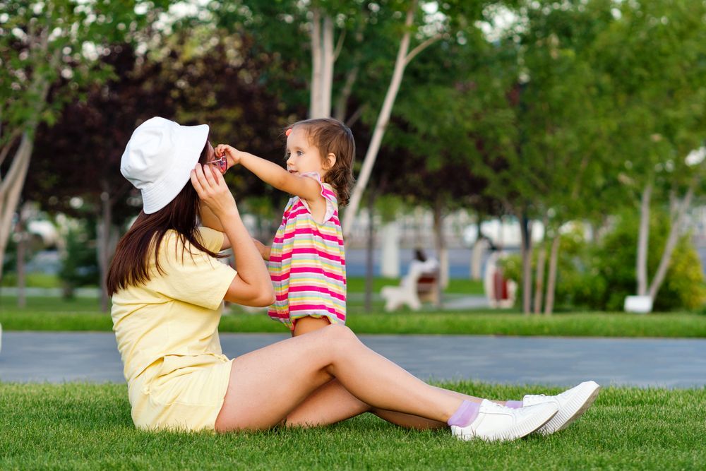 Toddler girl and mom in grass