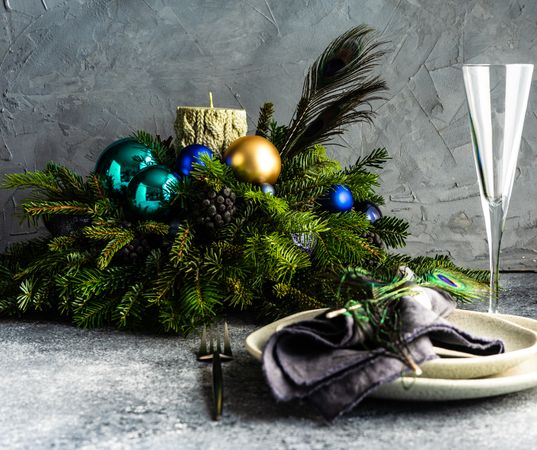 Side view of elegant festive table setting for Christmas dinner with peacock feathers