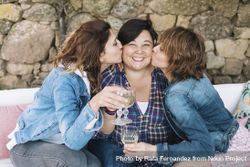 Portrait of three woman having fun kissing friend outdoors and smiling 4OdLJg