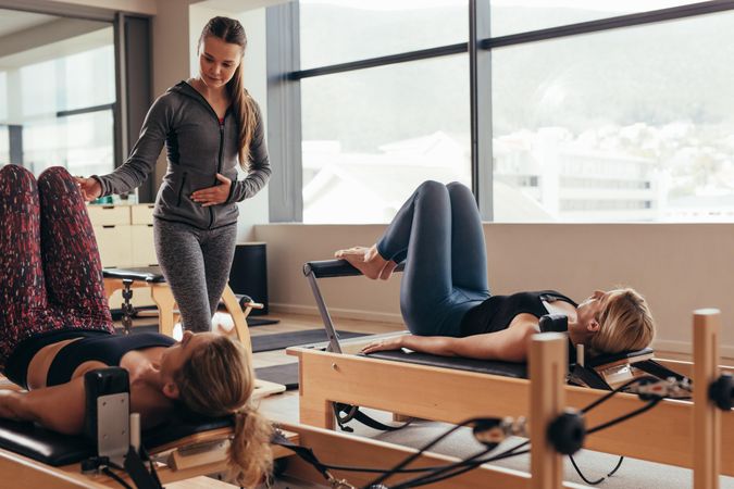 Two fitness women training at a pilates gym