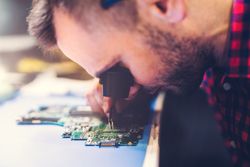 Man soldering motherboard at workplace