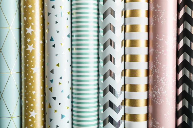 Rolls of festive wrapping paper as background. Top view