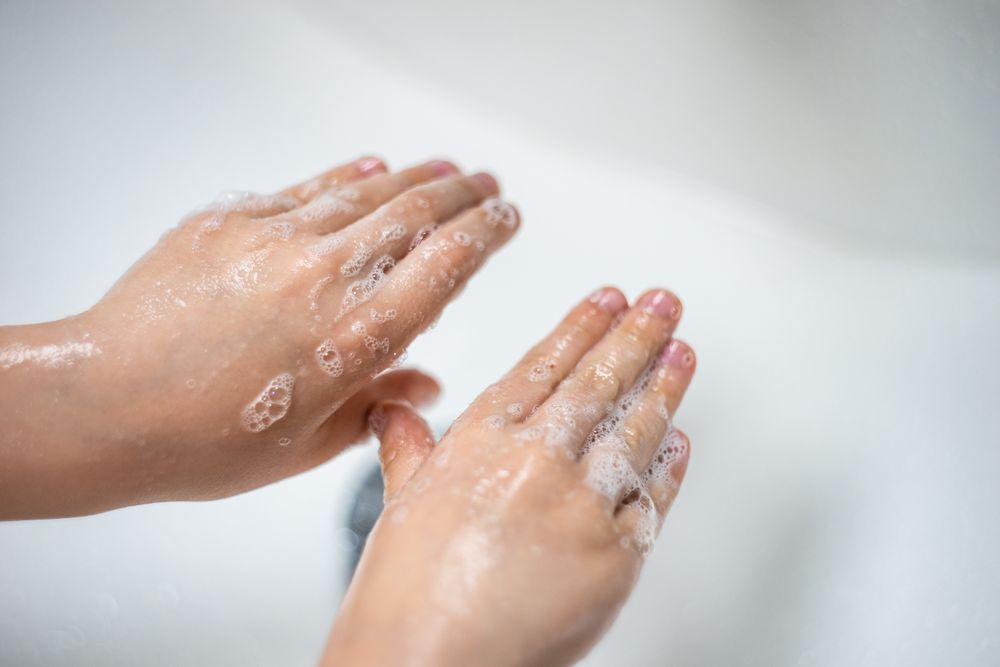 Person washing their hands in the sink