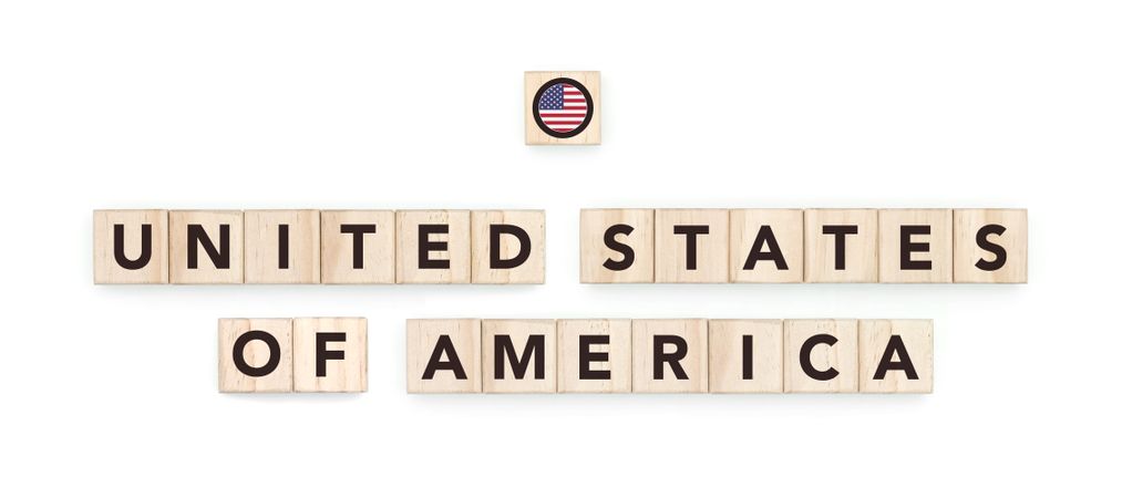 Wooden blocks bearing the name and flag of United States Of America. American Culture, national identity, travel, and geography in a copy space design.