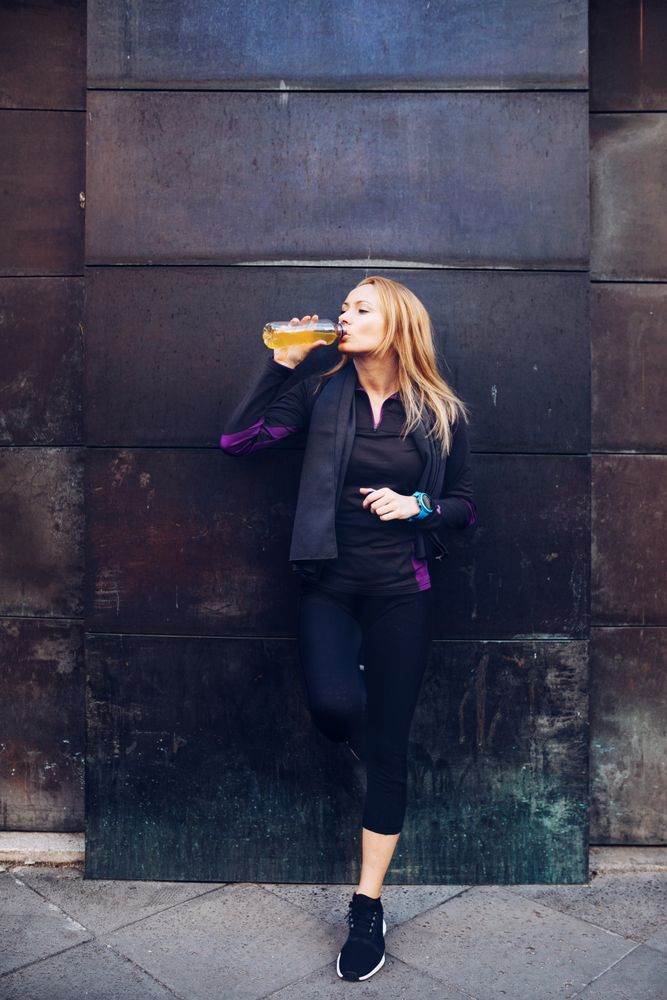 Woman drinking isotonic drink while resting