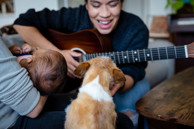 Woman playing music for baby and dog