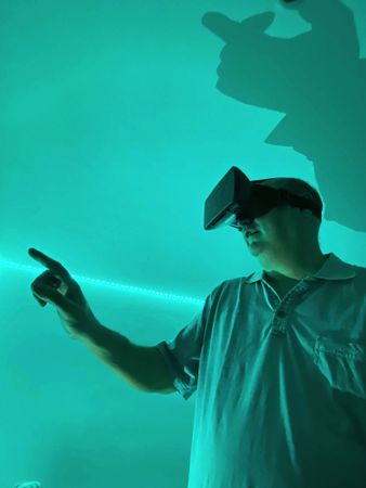 Man wearing virtual reality headset in green lit room