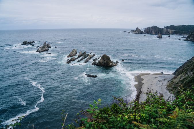 Rocky peaks surrounded by foamy water in windy day