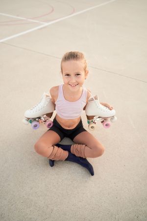 Positive roller skater girl holding white quads