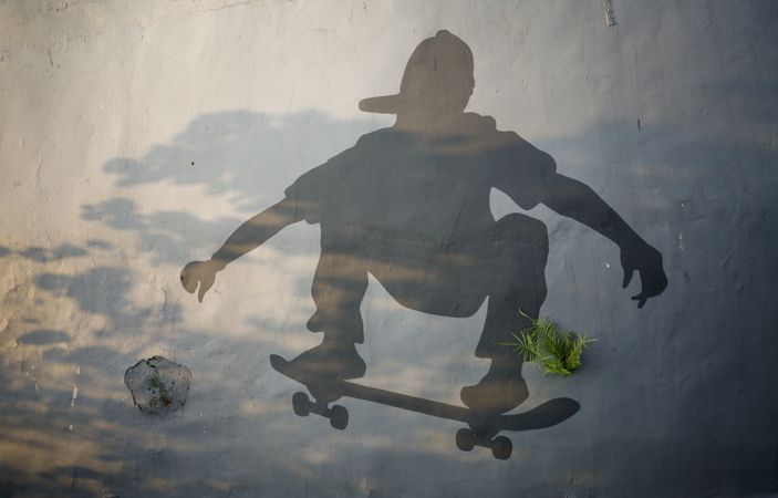 Shadow of person on skateboard on wall