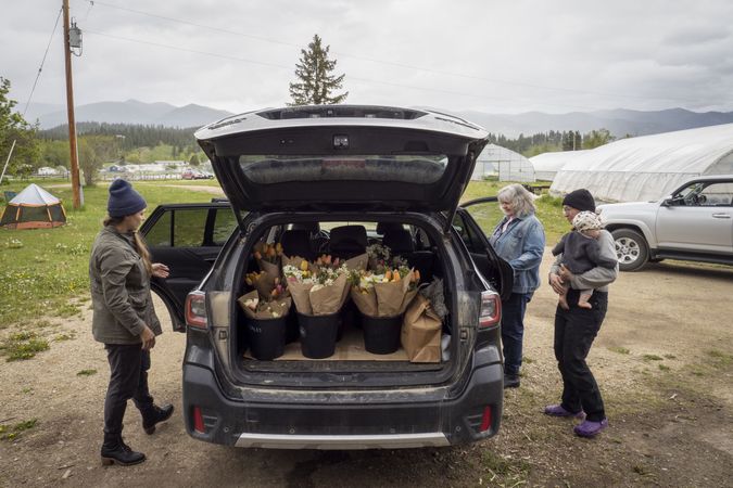 Women loading up back of car with fresh floral bouquets