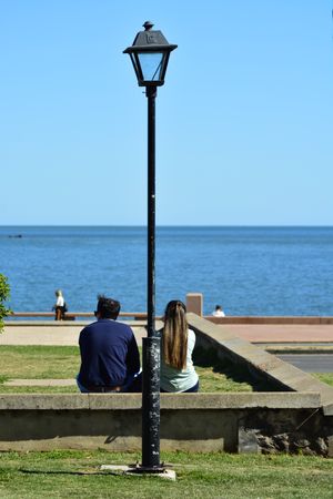 Back of two people sitting enjoying the ocean view