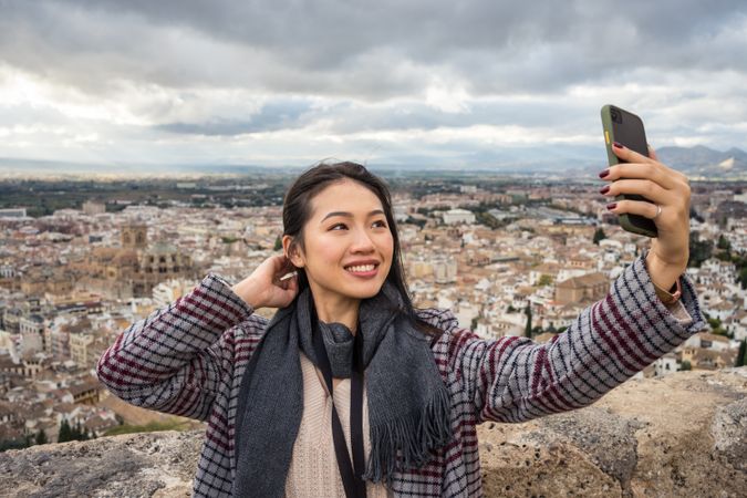 Asian tourist taking selfie against old city