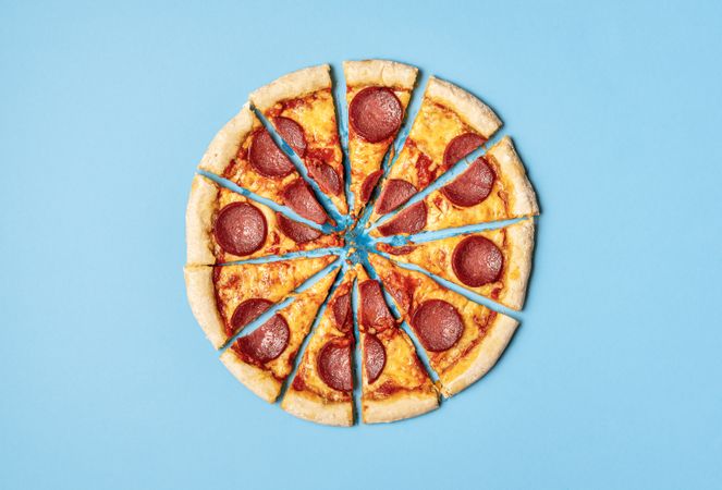 Sliced pizza pepperoni on blue background