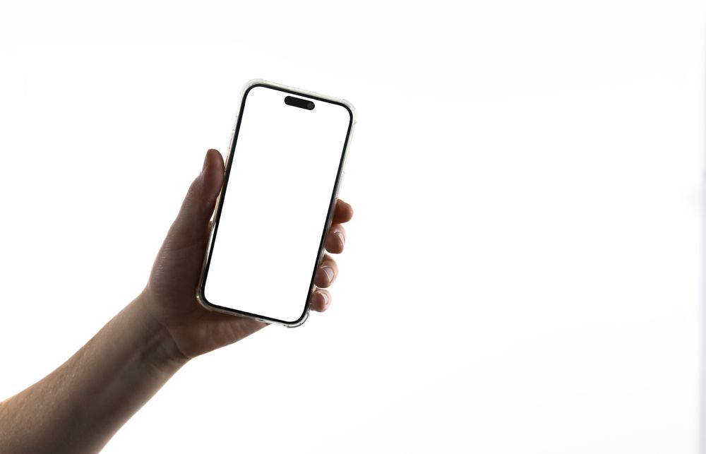 Hand holding smartphone on light background