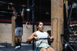 Hispanic sportswoman exercising on rowing machine