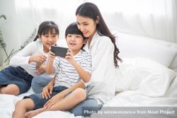 Happy family watching movie on smartphone 0L2LR4