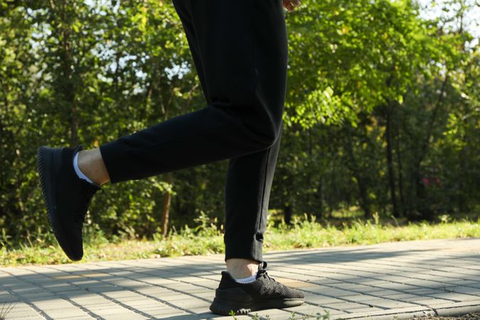 A man in a tracksuit running in the park in sunny morning