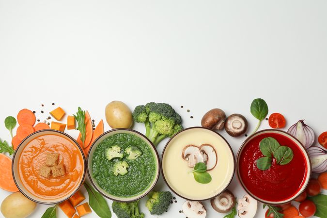 Row of colorful soups on bottom of picture with copy space