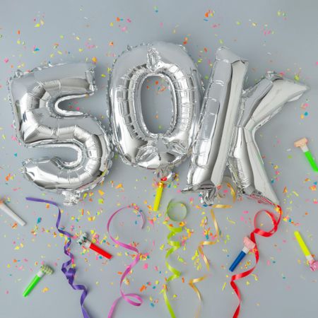 Silver balloons reading 50k with confetti