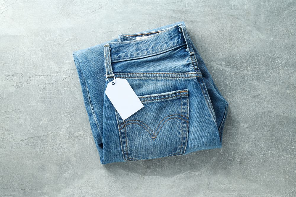 Folded jeans with a tag on a light background
