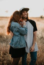 Hipster couple bonding on field in sunlight