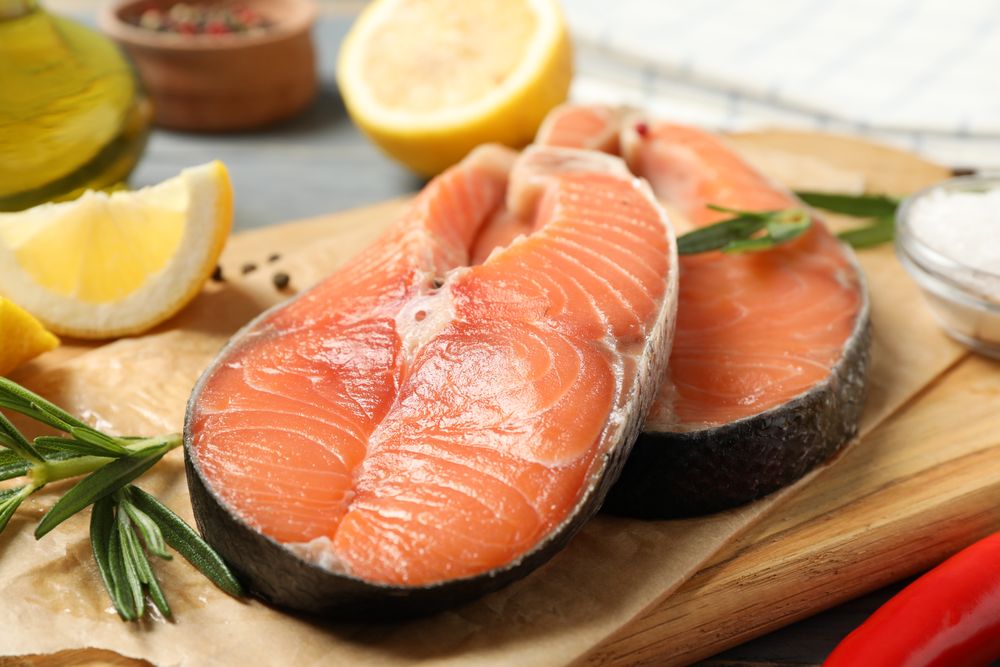 Composition with salmon meat and spices on wooden background, close up