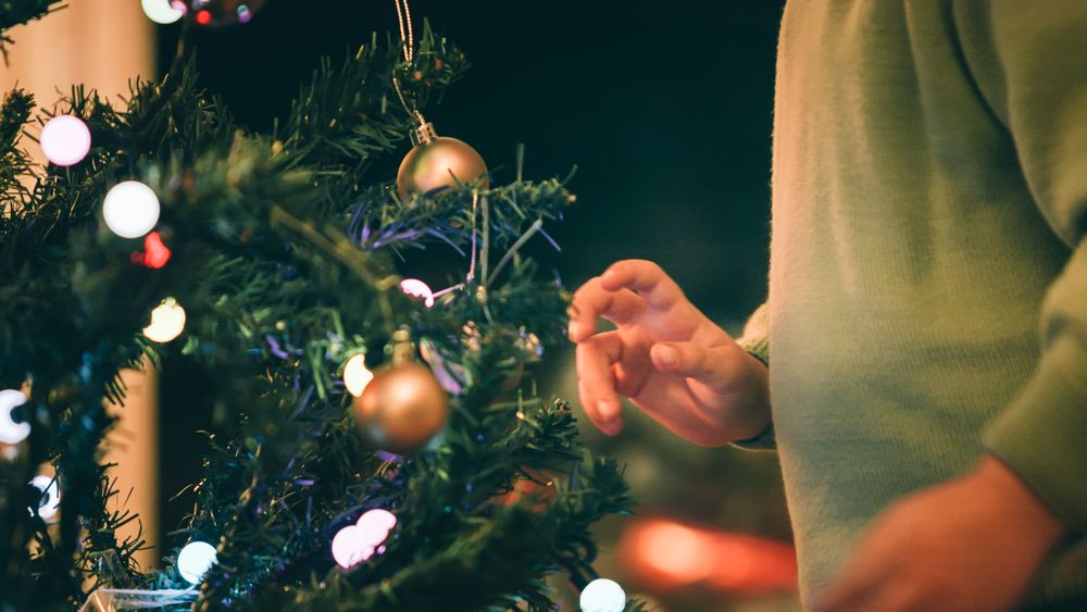 Boy decorating Christmas tree in evening