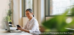 Businesswoman in office using phone 4d8P9N